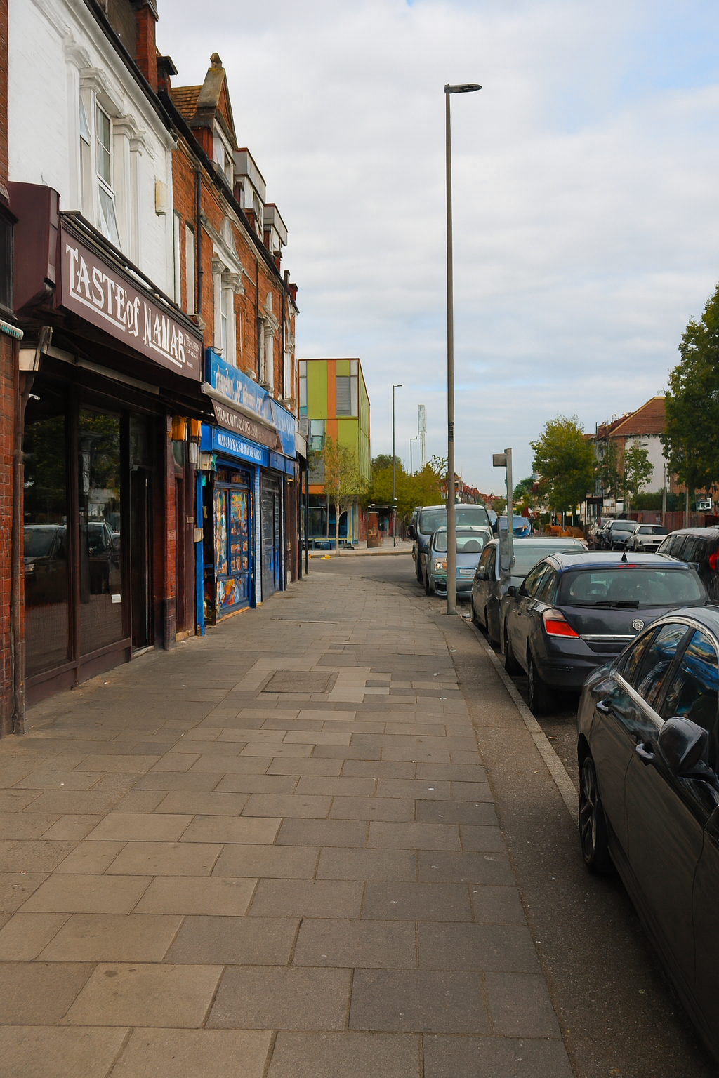 An image of a street with buildings and trees